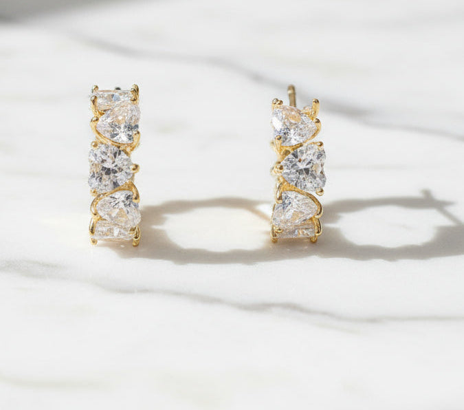 Gold and crystal earrings on a white background with 'Precious' branding.